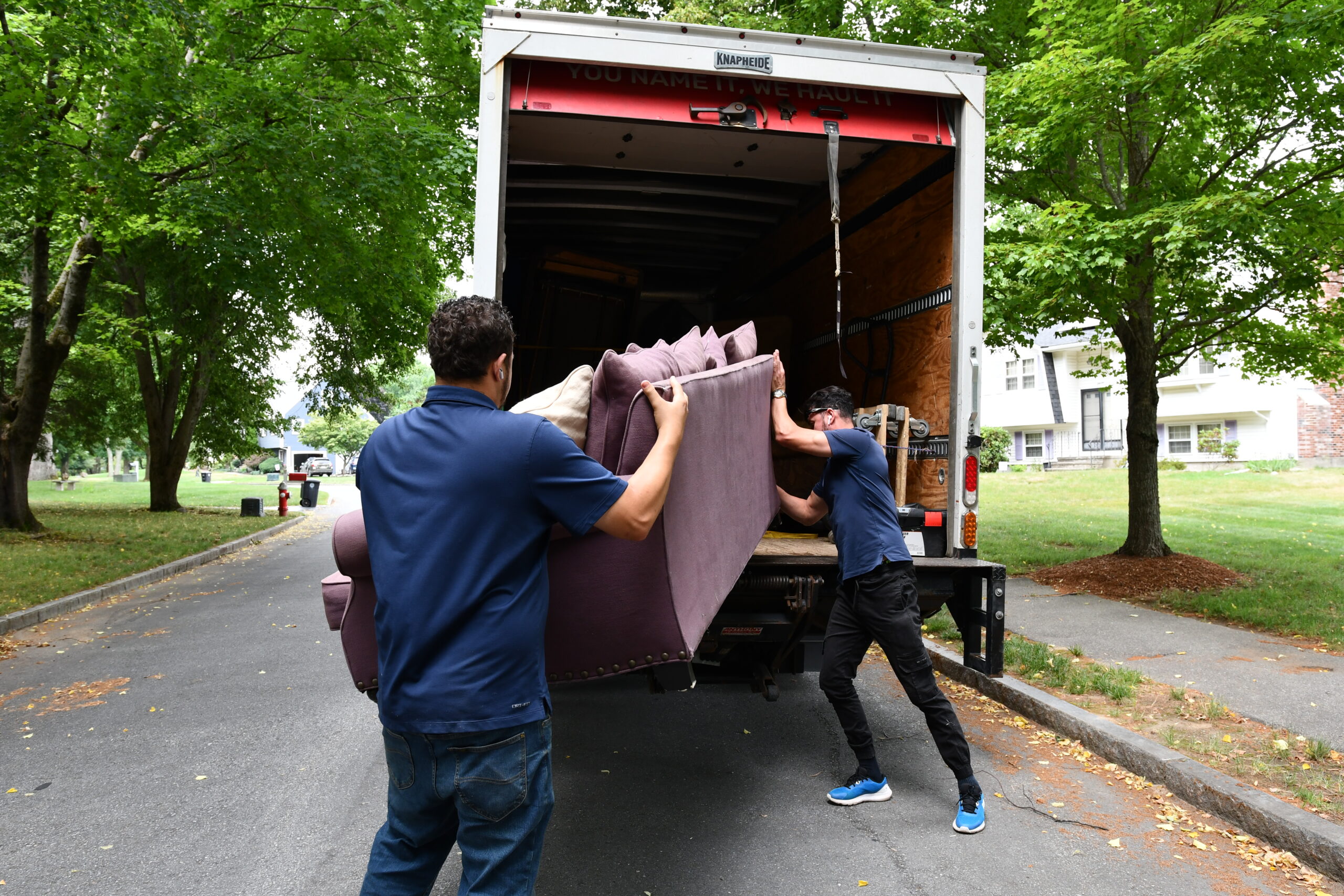 men loading a couch into a truck